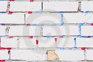 Beautiful abstract background from grungy dirty white brick wall. With remnants of paint and stains from graffiti. Urban