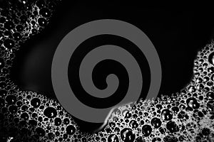 Beautiful abstract foam white bubbles on dark black background and soap black bubble and detergent photo