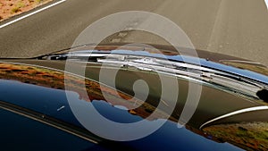 Beautiful abstract high angle shot from sunroof, road reflecting in windshield of car driving along American highway.