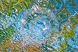 Beautiful abstract water reflection in blue, yellow and green colors.