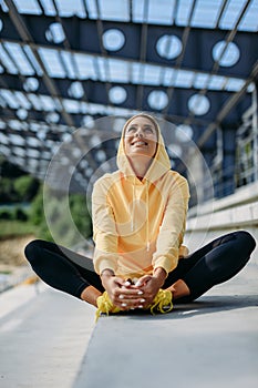 Beautiful active lady in sport clothing sitting on steps