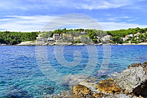 Beautiful Adriatic sea in Croatia. Blue lagoon  houses in green pines  rocky coast