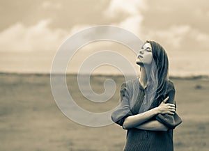 Beautiful adult girl in sweater at wheat field