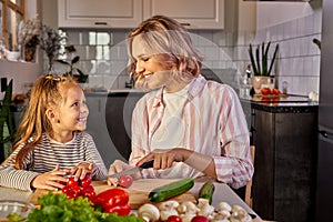 beautiful adult mother and daughter are going to prepare fresh salad together