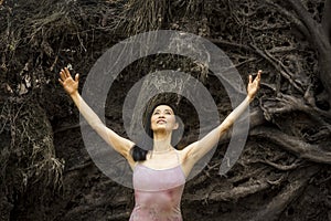 Active woman dancing with overturned tree roots in Manchester, Connecticut