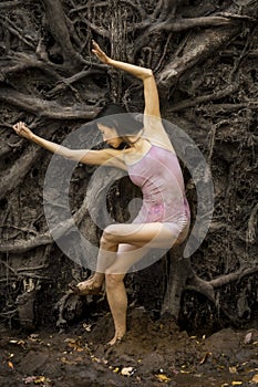 Active woman dancing with overturned tree roots in Manchester, Connecticut