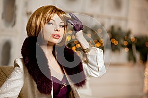 Beautiful adult woman in winter coat with fur. Trendy modern bl