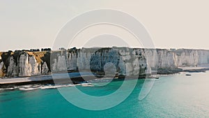 Beautiful aerial background shot of sunset azure sea coast and incredible white chalk cliffs near Etretat Normandy.