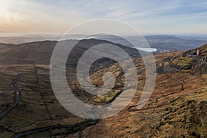 Beautiful aerial drone landscape image of sunrise Winter view from Red Screes in Lake District looking towards Windermere in the