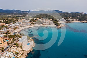 Beautiful aerial drone view shot of Peguera town on rocky Mediterranean cliff coast with cozy tranquil turquoise bays washed with