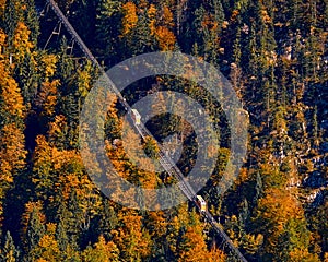 Beautiful aerial fall view of cable car ropeway funicular in austrian alps. Red cable railway car in the mountains