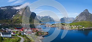 Beautiful aerial panorama of the blue sea surrounding the fishing village and rocky peaks Reine, Moskenes, Lofoten, Norway, sunny