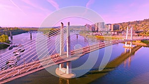 Beautiful Aerial Shot of Tilikum Crossing Bridge with Tram Crossing it During Golden Hour Sunrise in Portland, Oregon