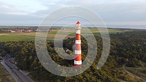 Beautiful aerial view of the Bornrif Lighthouse surrounded by lush trees in Ameland, the Netherlands