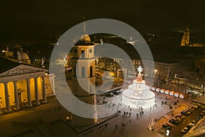 Beautiful aerial view of decorated and illuminated Christmas tree on the Cathedral Square at night in Vilnius. Celebrating