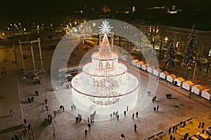 Beautiful aerial view of decorated and illuminated Christmas tree on the Cathedral Square at night in Vilnius. Celebrating