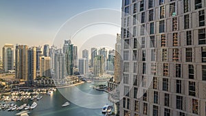 Beautiful aerial view of Dubai Marina promenade and canal with floating yachts and boats before sunset in Dubai, UAE.