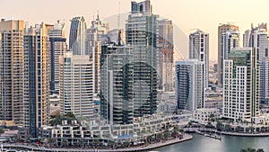 Beautiful aerial view of Dubai Marina promenade and canal with floating yachts and boats before sunset in Dubai, UAE.