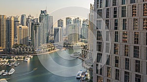 Beautiful aerial view of Dubai Marina promenade and canal with floating yachts and boats before sunset in Dubai, UAE.