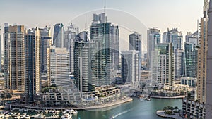 Beautiful aerial view of Dubai Marina promenade and canal with floating yachts and boats before sunset in Dubai, UAE.