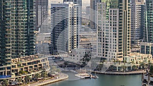 Beautiful aerial view of Dubai Marina promenade and canal with floating yachts and boats before sunset in Dubai, UAE.