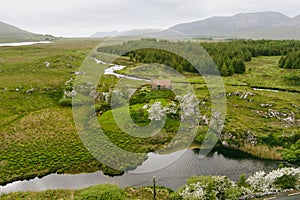 Beautiful aerial view of old rusty tin roof cottage, located in Connemara region in Ireland. Scenic Irish countryside landscape