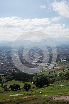 Beautiful aerial view of Oviedo. Green fields and mountains around the city. Sunny day, no people. Asturias