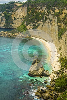 Beautiful aerial view of tropical paradise beach and rock cliff with amazing turquoise sea water and palm trees in Summer holidays