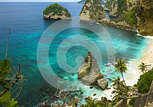 Beautiful aerial view of tropical paradise beach and rock cliff with amazing turquoise sea water and palm trees in Summer holidays