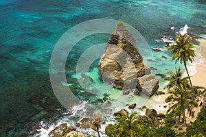 Beautiful aerial view of tropical paradise beach and rock cliff with amazing turquoise sea water and palm trees in Summer holidays