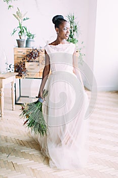 Beautiful african american bride with tropical bouquet in studio