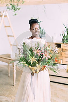 Beautiful african american bride with tropical bouquet in studio