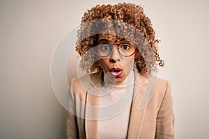 Beautiful african american businesswoman wearing glasses over isolated white background afraid and shocked with surprise