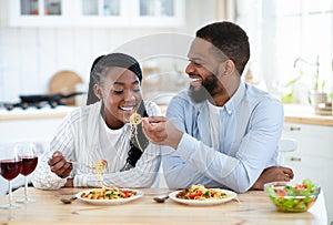 Beautiful african american couple having romantic lunch together in kitchen