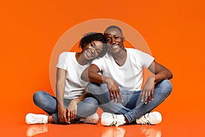 Beautiful african american couple sitting on floor and hugging