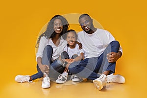 Beautiful african american family sitting on floor and smiling