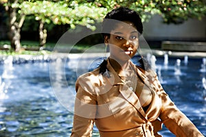 African american  female fashion model with an Afro is sitting in a park by in Chicago.