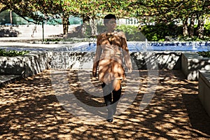 African american  female fashion model with an Afro is walking in a park