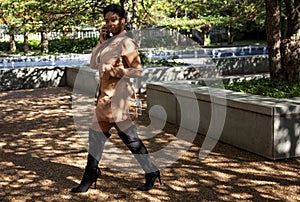 African american  female fashion model with an Afro is walking in a park