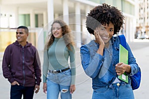 Beautiful african american female student with backpack and group of international students