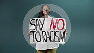 Beautiful African American girl proudly holding a Say No to racism sign