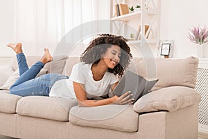 Beautiful african-american girl reading book at home