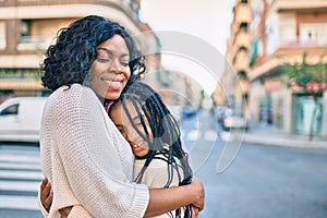 Beautiful african american mother and daughter smiling happy and hugging