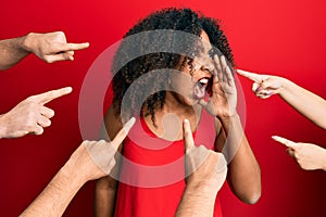 Beautiful african american woman with afro hair with fingers around pointing to herself shouting and screaming loud to side with