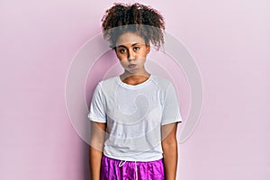 Beautiful african american woman with afro hair wearing sportswear puffing cheeks with funny face