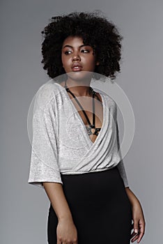 Beautiful african american woman with curly hairstyle wearing stylish clothes and leather female sword belt