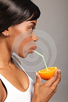 Beautiful african american woman with orange fruit