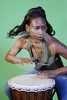 Beautiful African-American woman playing drums