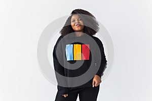 Beautiful African American woman posing in black sweatshirt on a white background. Street fashion photo with afro