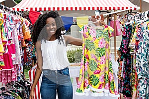 Beautiful african american woman selling clothes at market